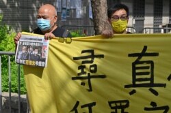 Supporters of two executives from Hong Kong's Apple Daily newspaper, chief editor Ryan Law and CEO Cheung Kim-hung, protest outside court in Hong Kong on June 19, 2021.