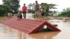 Villagers take refuge on a rooftop above flood waters from a collapsed dam in the Attapeu district of southeastern Laos, July 24, 2018. 