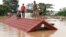 Villagers take refuge on a rooftop above flood waters from a collapsed dam in the Attapeu district of southeastern Laos, July 24, 2018. 