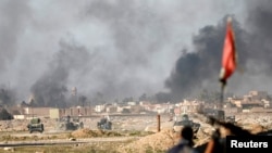 Smoke rises during a battle between Islamic State fighters and Iraqi troops at an outskirts of Mosul, Iraq, Feb. 25, 2017 