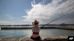 Florentino Toca fishes in Havana Bay, Cuba, Aug. 21, 2019. Six decades ago, the U.S. implemented an embargo against Cuba to bring down the communist government. Many experts say it instead harmed the population while generating resilience.