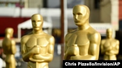 FILE - Oscar statues stand off of Hollywood Boulevard in preparation for Sunday's 92nd Academy Awards at the Dolby Theatre, Feb. 5, 2020, in Los Angeles.