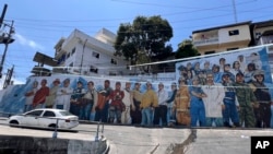 Un mural que muestra a miembros de las fuerzas de seguridad junto a trabajadores del servicio público cubre una pared en una calle que conduce al barrio Cerro de Santa Ana en Guayaquil, Ecuador, el martes 4 de febrero de 2025. AP