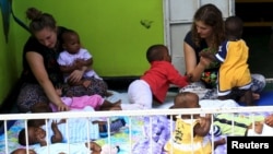 A health worker, center, distributes leaflets on how people should protect themselves from the new coronavirus, in Lagos, Nigeria, March 31, 2020.