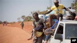 Refugees who fled the recent violence in South Sudan and crossed the border into Uganda arrive and await transportation from a transit center in the town of Koboko, Uganda, to a nearby settlement in Arua District, in northern Uganda Monday, Jan. 6, 2014. 