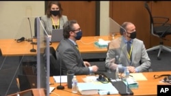 In this image from video, defense attorney Eric Nelson, left, and defendant, former police officer Derek Chauvin, right, listen during jury selection in Chauvin's trial, at the Hennepin County Courthouse in Minneapolis, Minnesota, March 9, 2021.