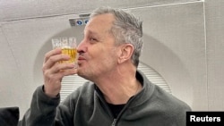 Marc Fogel gestures on an airplane flying him back to the United States