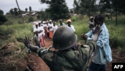 Un milicien du groupe armé URDPC/CODECO de la communauté Lendu arrête une procession religieuse de la secte CODECO dans le village de Masumbuko, province de l'Ituri, nord-est de la RDC, le 18 septembre 2020.