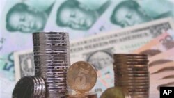 FILE - Coins, banknotes of Chinese yuan, paired with a U.S. dollar during photo illustration, Fuyang, Anhui province.