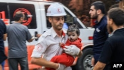 A Palestinian paramedic carries a child injured in an Israeli airstrike at the Nasser Hospital in Khan Yunis in the southern Gaza Strip, on Oct. 17, 2023.