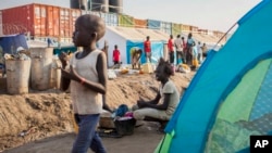FILE - A young displaced girl washes clothes alongside a row of tents in the United Nations camp in Juba, South Sudan, Feb. 12, 2014.