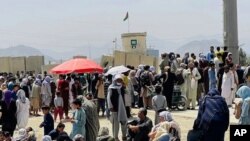 Cientos de personas se ven reunidas frente al aeropuerto internacional en Kabul, Afganistán, el 17 de agosto de 2021, con la esperanza de tomar un vuelo fuera del país.