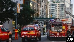 Firefighters inspect a construction crane tha caught fire and collapsed in New York, on July 26, 2023.