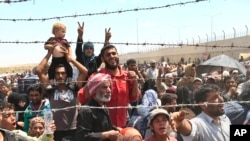 FILE - Syrian refugees gather in Akcakale, southeastern Turkey, after fleeing intense fighting, June 15, 2015.