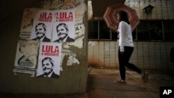 This Jan. 29, 2018 photo shows a wall displaying posters with line drawings that depict Brazil's former President Luiz Inacio Lula da Silva and a message that says “Lula is innocent" in Portuguese, Brasilia, Brazil. 