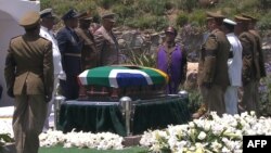 A screengrab taken from the South African Broadcasting Corporation live feed shows members of the South African armed forces standing around the coffin of late former President Nelson Mandela before it is lowered into the grave during his funeral in Qunu, Dec. 15, 2013. 