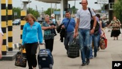 D&#226;n ch&#250;ng mang theo vật dụng t&#249;y th&#226;n đi bộ sang trạm kiểm so&#225;t ở Izvaryne, v&#249;ng Luhansk ở miền đ&#244;ng Ukraine để v&#224;o l&#227;nh thổ Nga, 26/6/14