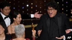 Bong Joon Ho, right, reacts as he is presented with the award for best picture for "Parasite" from presenter Jane Fonda at the Oscars on Sunday, Feb. 9, 2020, at the Dolby Theatre in Los Angeles. Looking on from left are Kang-Ho Song and Yeo-Jeong Cho.(AP)