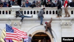 FILE - A mob of supporters of U.S. President Donald Trump fight with members of law enforcement at a door they broke open as they storm the U.S. Capitol Building in Washington, Jan. 6, 2021. 