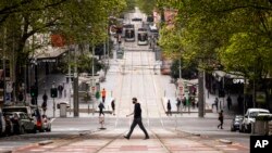 People cross Bourke Street in Melbourne, Australia, Sept. 30, 2021. 