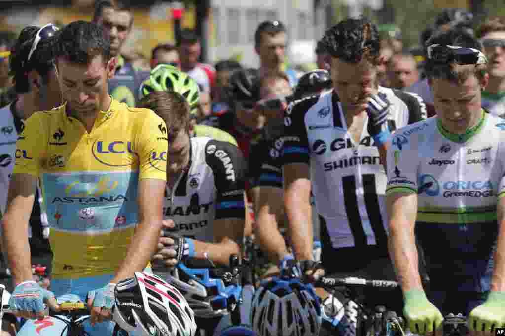 A pack of cyclists, with Italy&#39;s Vincenzo Nibali, observe a minute of silence for the victims of the Malaysia Airlines Flight 17 plane crash prior to the start of the thirteenth stage of the Tour de France cycling race, Chamrousee, France, July 18, 2014.