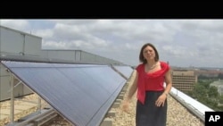 Meghan Chapple-Brown, director of Sustainability, stands by some of the solar hot-water systems that are on the rooftops of several buildings at George Washington University in urban Washington, D.C., June 2011