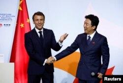 法国总统马克龙在北京向在华法国人讲话后与中国影星黄渤握手。（2023年4月5日）