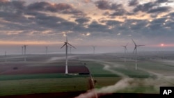 FILE - Wind turbines operate at an energy plant near Stetten, north of Kaiserslautern, Germany, as the sun rises on, March 19, 2024. According to a new report published Tuesday, April 16, 2024, last year, marked the best year for new wind projects. (AP Photo/Michael Probst, File)