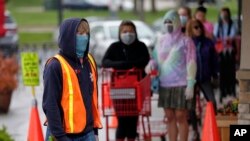 Doorman Dilon Moore controls the number of customers allowed to shop at one time at a Trader Joe's supermarket in Omaha, Nebraska, May 7, 2020.