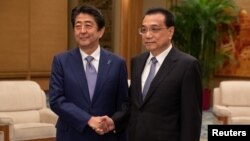 Chinese Premier Li Keqiang and Japanese Prime Minister Shinzo Abe shake hands during their meeting at the Great Hall of the People in Beijing, Oct. 25, 2018.