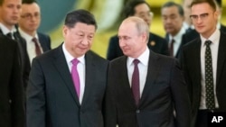 Russian President Vladimir Putin, right, and Chinese President Xi Jinping enter a hall for the talks in the Kremlin in Moscow, Russia, June 5, 2019. 