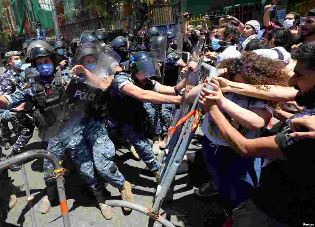 Demonstrators confront riot police as they try to cross barricades on a road leading to the UNESCO Palace where Lebanon's parliament is holding a legislative session, during a protest against a controversial amnesty draft law, in Beirut, Lebanon.