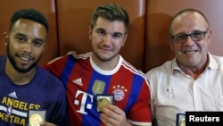 (ពីស្តាំទៅឆ្វេង) បុរស​បី​នាក់​ដែល​បាន​ជួយ​ទប់ស្កាត់​ខ្មាន់​កាំភ្លើង​ម្នាក់​ លើ​រថភ្លើង​ពី​ទី​ក្រុង​ Amsterdam​ ទៅ​ប្រទេស​បារាំង​គឺ​លោក​Anthony​ Sadler​ មក​ពី​ទី​ក្រុង​Pittsburg​ រដ្ឋ​California​ លោក​Aleck​ Sharlatos​ មក​ពី​ទី​ក្រុង​Roseburg​ រដ្ឋ​Oregon​ លោក​Chris​ Norman​ បុរស​ជន​ជាតិ​អង់គ្លេស​ដែល​រស់​នៅ​ក្នុង​ប្រទេស​បារាំង​ បាន​បង្ហោះ​រូប​ភាព​ជា​មួយ​មេដាយ​ដែល​ពួកគេ​បាន​ទទួល។