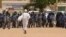 Anti-government protestor faces riot police last week in Khartoum. (A. Ahmed/VOA)