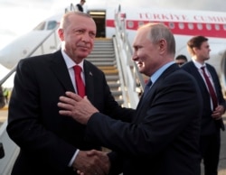 FILE - Russia's President Vladimir Putin, right shakes hands with Turkey's President Recep Tayyip Erdogan near Moscow, Aug. 27, 2019. Their two nations have called for a cease-fire in Libya.
