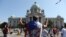 A protester raises his fists in front of the Serbian parliament during an anti-government rally, as deputies attend the first session of the National Assembly after June's national election, Aug. 3, 2020.