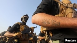 Members of Iraqi Popular Mobilization Forces demonstrate their skills during a military exercise at a graduation ceremony in Basra, Iraq, Jan. 31, 2019. 