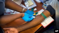 FILE - Blood is drawn from a clinical trials patient for the AstraZeneca test vaccine at the a hospital facility outside Johannesburg, South Africa, Nov. 30, 2020.