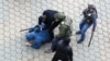 Unidentified people, who are presumably Belarusian law enforcement officers, restrain a man during a rally to reject the presidential election results in Minsk, Belarus, Nov. 8, 2020. 