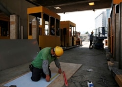 A worker repairs toll booths that were damaged during protests, at the Cross Harbour Tunnel near Hong Kong Polytechnic University in Hong Kong, Nov, 23, 2019.