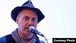 លោក Scott Bywater កវីកំណាព្យ​ និង​តន្រ្តីករ​​នៅ​តាម​បា​បារាំង​​នានា​ក្នុង​រាជ​ធានី​ភ្នំពេញ។ 