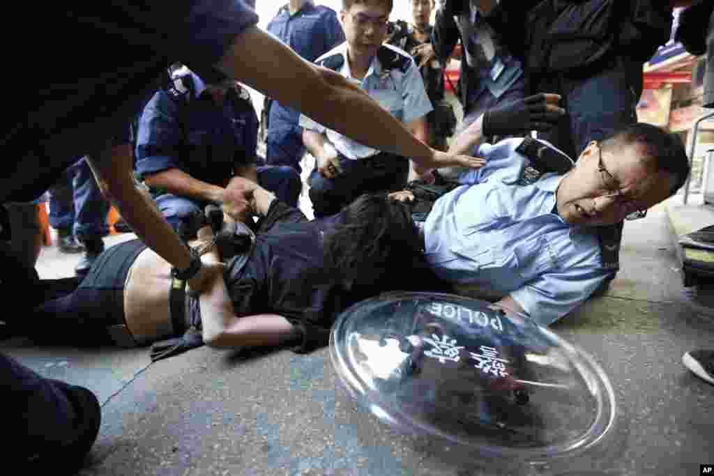 A pro-democracy protester is arrested by riot police in the Mong Kok district of Hong Kong, early Friday, Oct. 17, 2014.