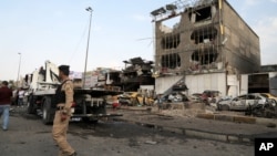 Security forces inspect the site of a car bomb explosion in the largely Shi'ite eastern neighborhood of Talibiyah in Baghdad, Iraq, Oct. 16, 2014. 