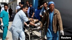 Men transport a victim to a hospital after a blast in Kabul, Afghanistan, March 21, 2018.