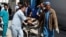 Men transport a victim to a hospital after a blast in Kabul, Afghanistan, March 21, 2018.