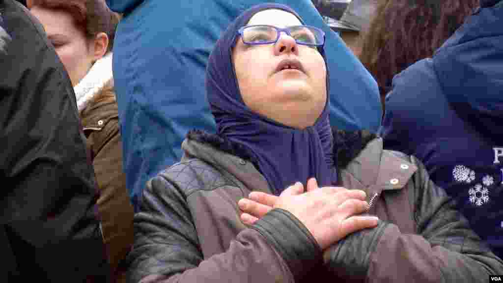 A woman mourns as hundreds of people gather at the Place de la Bourse in downtown Brussels following the terrorist attacks that left dozens of people dead, March 23, 2016. (L. Bryant/VOA)