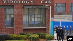 资料照片：在世界卫生组织团队来访之际，安全人权站在武汉病毒研究所入口附近。(2021年2月3日)