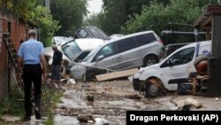 Ljudi na uliciu predgrađu Skopja Stajkovci, posle noćašnje oluje koja je izazvala poplave, gubitke života i veliku materijalnu štetu