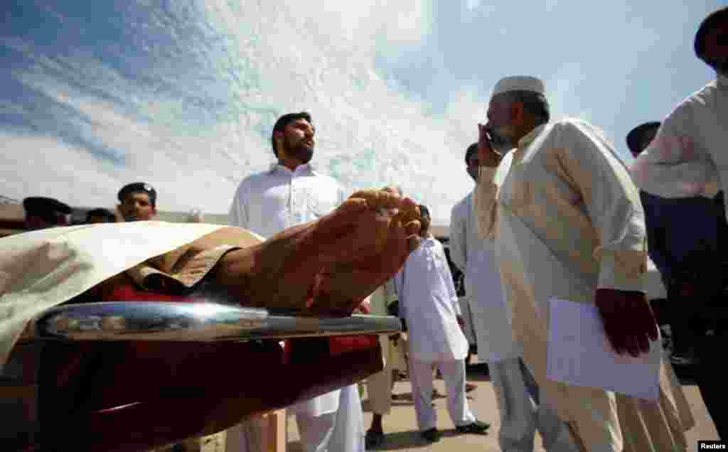 Relatives stand near a victim of the blast.