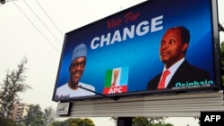 FILE - An electronic billboard displays a campaign poster of All Progressives Congress presidential candidate Mohammadu Buhari and running mate Yemi Osinbajo, who this week won Nigeria's democratic election.